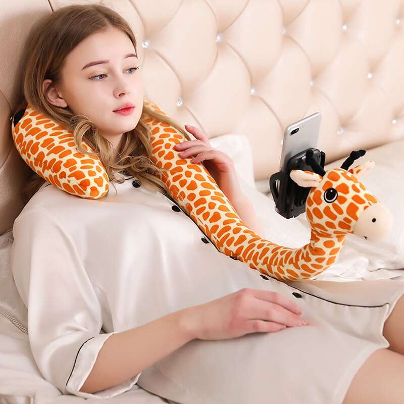 a woman laying on a bed with a giraffe pillow