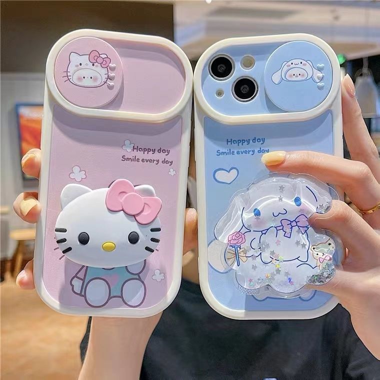 a woman holding two cell phones with hello kitty cases on them